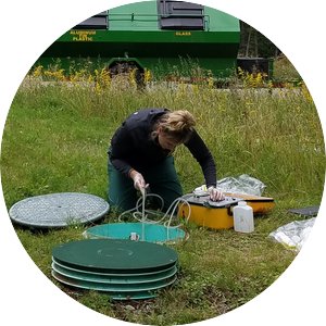 Researcher collecting samples from a septic system