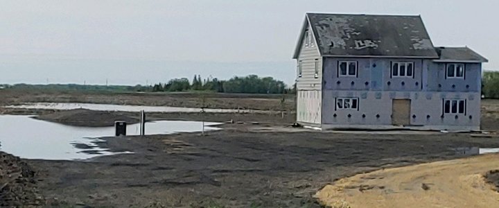 Partially built home with a mound septic system in a flooded area