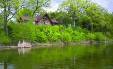 Home built on a lakeshore with a steep, vegetated embankment